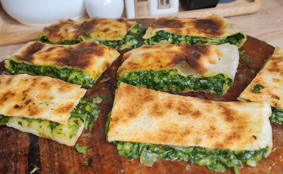 Questa pizza ripiena di spinaci e formaggio mi ricorda quando le faceva la mia nonna: è sottile, leggera e tanto saporita!